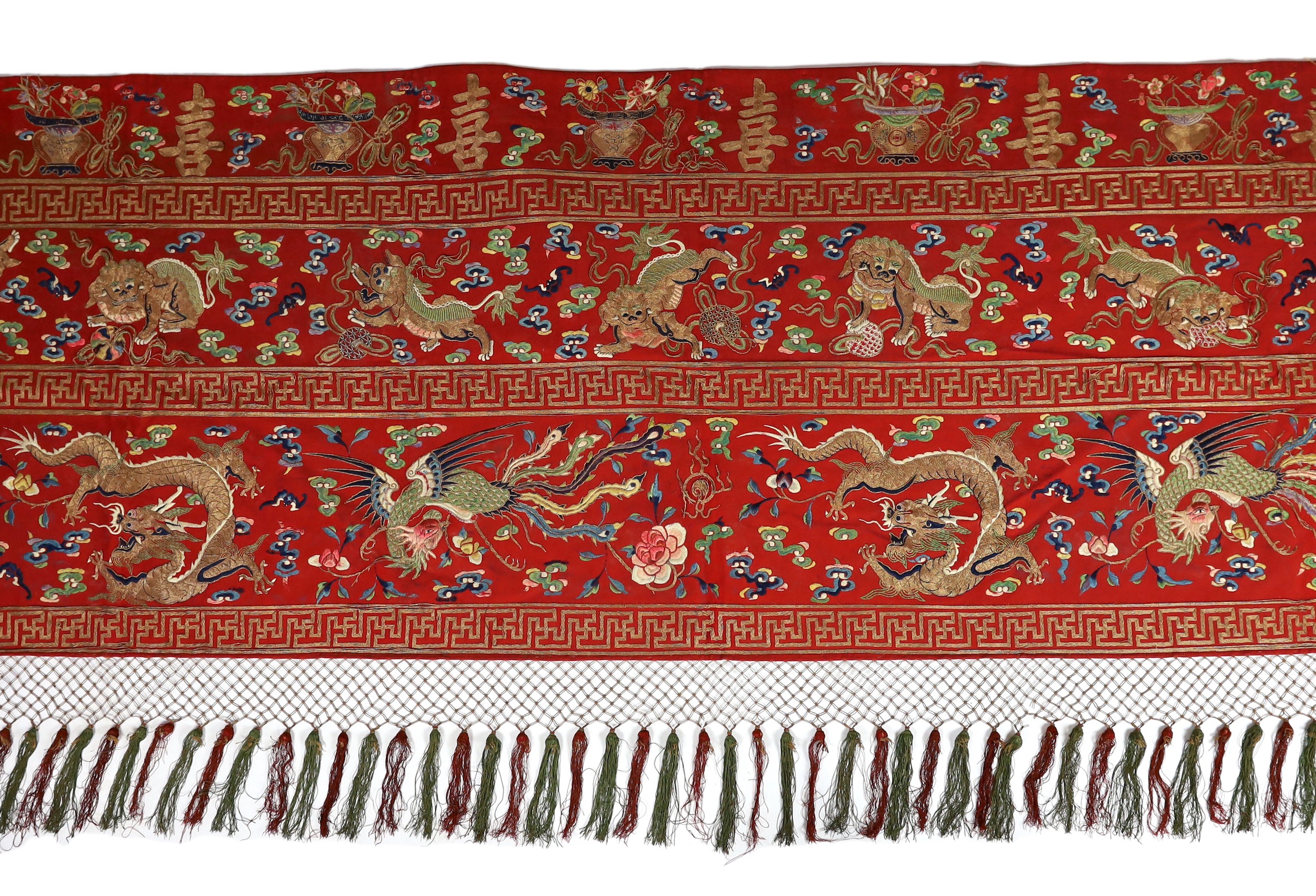 A Chinese embroidered silk ‘dragon, phoenix and lion’ panel or table frontal, late Qing dynasty, 117cm x 337cm